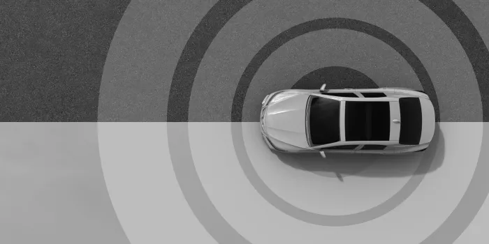 Top view of a car with radar-like circles, symbolizing sensing technology.